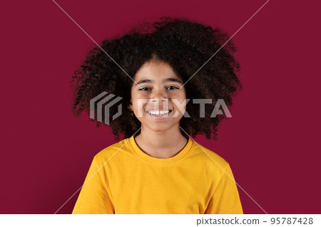 Portrait of smiling african american kid girl on burgundy background 95787428