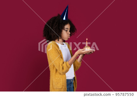 Adorable black girl having birthday party, blowing candle Adorable black girl having birthday party, blowing candle 95787550