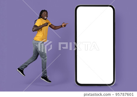 Emotional black guy jumping by huge smartphone, mockup Emotional black guy jumping by huge smartphone, mockup 95787601