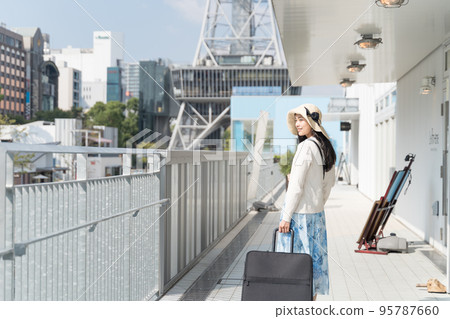 A young woman pulling a suitcase and sightseeing in Nagoya 95787660
