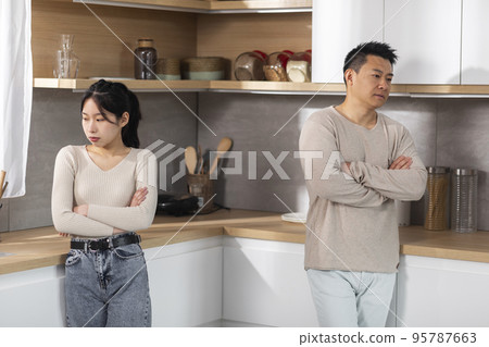 Upset korean lovers standing at kitchen, having quarrel 95787663
