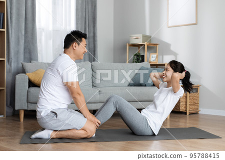 Side view of athletic korean man and woman exercising together Side view of athletic korean man and woman exercising together 95788415