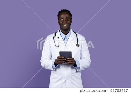Friendly african american doctor holding digital tablet Friendly african american doctor holding digital tablet 95788417