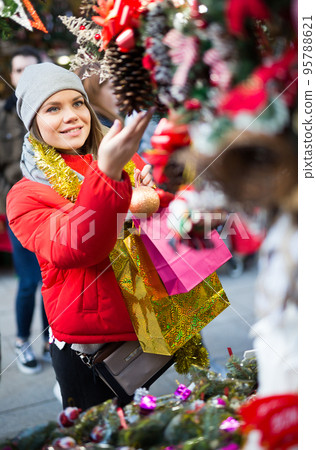 Young female near counter with xmas gifts on street market Young female near counter with xmas gifts on street market 95788621