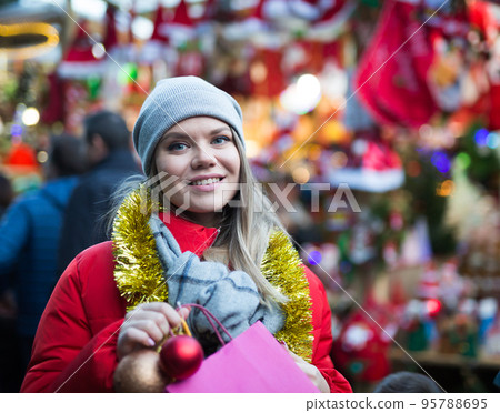 Happy girl chooses Christmas toys on the street market 95788695