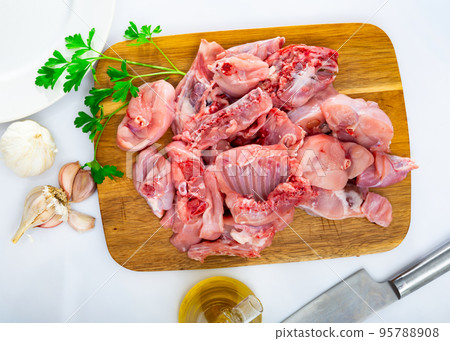 Chopped rabbit with onion, garlic and spices on kitchen board with knife 95788908