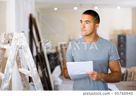 Man designer checking documents during repair works 95788940