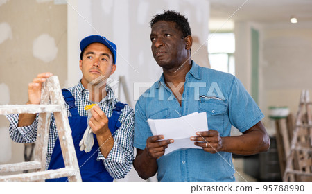 Owner of apartment indicates to foreman where and what to repair 95788990