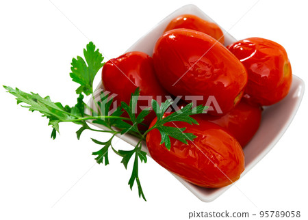White salad bowl with pickled tomatoes on table 95789058