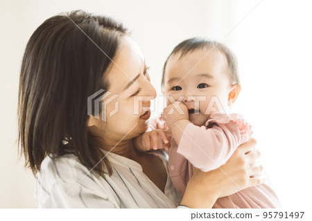 smiling mom holding a baby smiling mom holding a baby 95791497