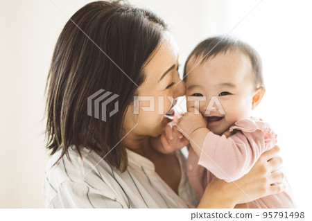 微笑著抱著嬰兒的媽媽 95791498