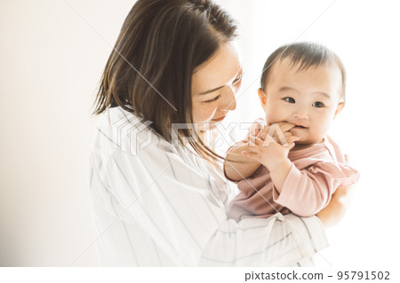 smiling mom holding a baby smiling mom holding a baby 95791502