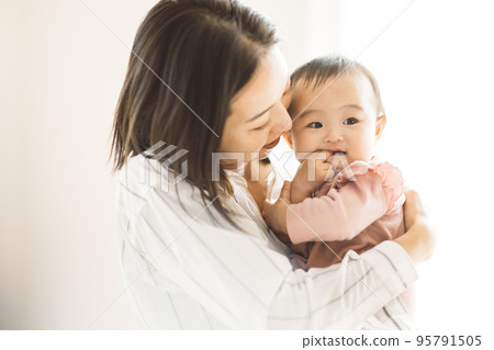 smiling mom holding a baby smiling mom holding a baby 95791505