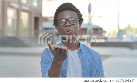 Loving Young African Man Giving Flying Kiss by Hands Outdoor 95796487