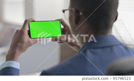 Young African Businessman Looking at Smartphone with Chroma Screen 95796523
