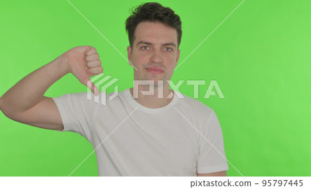 Thumbs Down by Young Man on Green Background Thumbs Down by Young Man on Green Background 95797445