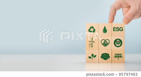 ESG concept of environmental, social and governance. Sustainable corporation development. Hand holds wooden cubes with abbreviation ESG. banner, copy space 95797483
