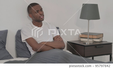 Young African Man Sitting in Bed Young African Man Sitting in Bed 95797842