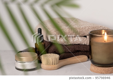 Skin care product for oil face massage and flowers on white table. Eco friendly organic reusable self care accessories. Skin care product for oil face massage and flowers on white table. Eco friendly organic reusable self care accessories. 95798946