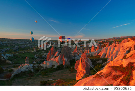 Sunrise panoramic view to Goreme city and flying balloons, Cappadocia, Turkey Sunrise panoramic view to Goreme city and flying balloons, Cappadocia, Turkey 95800685
