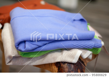 Colorful women's dresses on hangers in a retail shop. Colorful women's dresses on hangers in a retail shop. 95800829