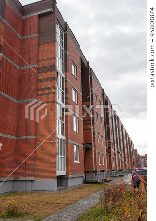 Windows of a residential multi-storey brick house. Modern buildings. Windows of a residential multi-storey brick house. Modern buildings. 95800874