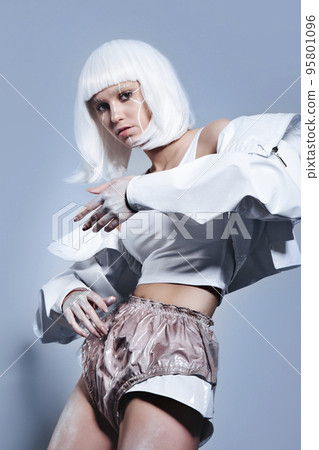 Virtual life concept. Woman in silver latex costume with futuristic hairstyle and make-up on grey background Virtual life concept. Woman in silver latex costume with futuristic hairstyle and make-up on grey background 95801096
