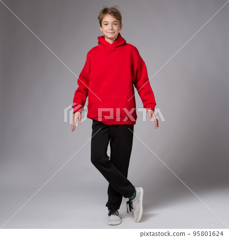 A smiling teenager boy, in a red hoodie and black sweatpants, arms outstretched A smiling teenager boy, in a red hoodie and black sweatpants, arms outstretched 95801624