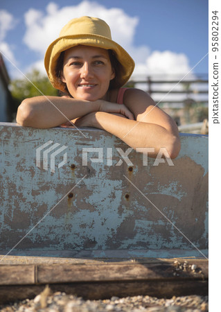 Smiling tanned female in yellow hat relaxing posing on sunny beach enjoy summer travel vacation Smiling tanned female in yellow hat relaxing posing on sunny beach enjoy summer travel vacation 95802294