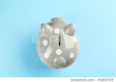 Grey piggy bank on light blue background, top view Grey piggy bank on light blue background, top view 95802419