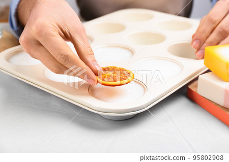 Woman making natural handmade soap at white table, closeup 95802908