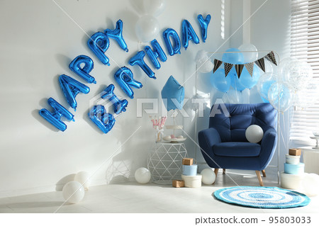 Phrase HAPPY BIRTHDAY made of blue balloon letters in decorated room Phrase HAPPY BIRTHDAY made of blue balloon letters in decorated room 95803033