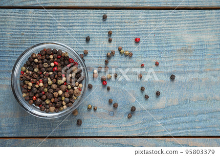 Mixed peppercorns in jar on blue wooden table, flat lay 95803379