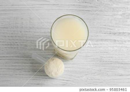 Protein shake and powder on white wooden table, above view Protein shake and powder on white wooden table, above view 95803461