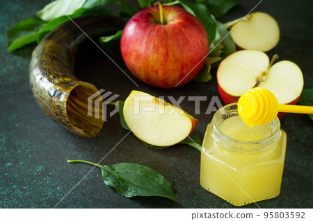 Background Rosh hashanah (Jewish New Year). Traditional holiday symbols - shofar, honey and apple on a stone or slate background. Background Rosh hashanah (Jewish New Year). Traditional holiday symbols - shofar, honey and apple on a stone or slate background. 95803592