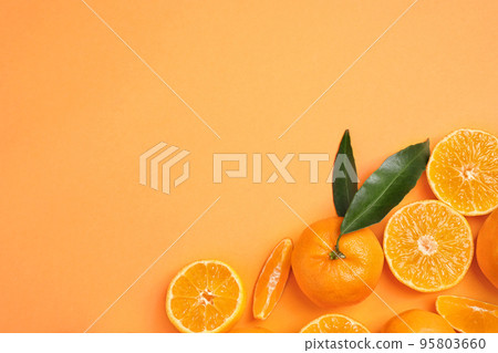 Flat lay composition with fresh ripe tangerines and space for text on orange background. Citrus fruit 95803660