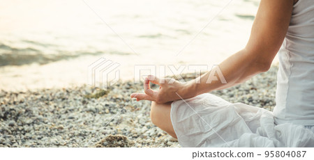 Woman meditating at the Garda Lake. Sunset. Woman meditating at the Garda Lake. Sunset. 95804087