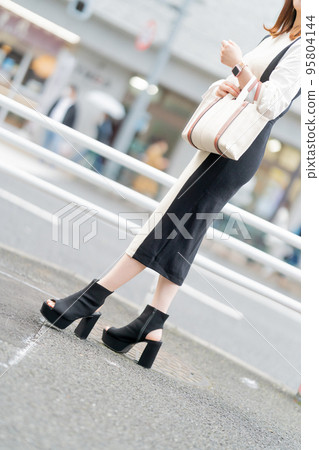 Feet of a young woman with a bag 95804144