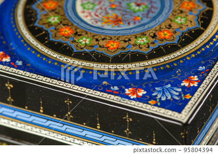 A closeup of a casket with an artistic painting on a black background. Central Asia, Uzbekistan 95804394