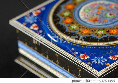 A closeup of a casket with an artistic painting on a black background. Central Asia, Uzbekistan 95804395