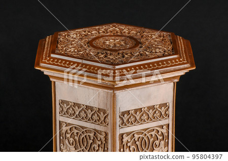 The antique oriental wooden table with the artistic carving on a black background, Uzbekistan, close-up The antique oriental wooden table with the artistic carving on a black background, Uzbekistan, close-up 95804397
