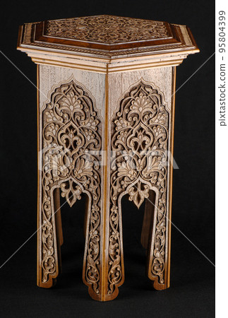 A vintage oriental wooden table with artistic carving isolated on a black background A vintage oriental wooden table with artistic carving isolated on a black background 95804399