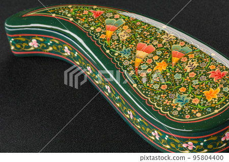 A closeup of a casket with an artistic painting on a black background. Central Asia, Uzbekistan A closeup of a casket with an artistic painting on a black background. Central Asia, Uzbekistan 95804400