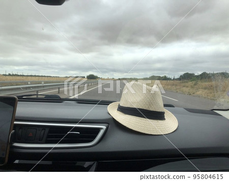 A hat in the car Rural landscape outside the window 95804615