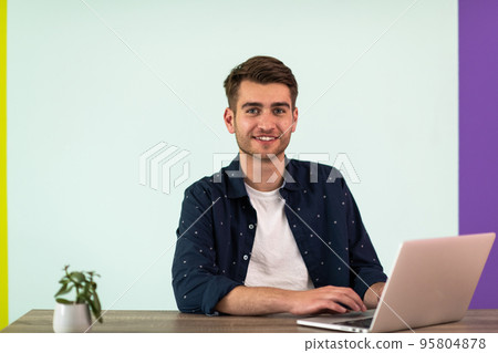Smiling young man freelancer using laptop studying online working from home Smiling young man freelancer using laptop studying online working from home 95804878