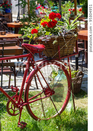 White decorative old bike with a basket of flowers against a brick wall. Copy space White decorative old bike with a basket of flowers against a brick wall. Copy space 95804951