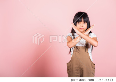 Asian little kid 10 years old showing two hands cross arms say no X sign Asian little kid 10 years old showing two hands cross arms say no X sign 95805343