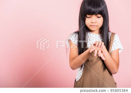 Asian little kid 10 years old scratching itch back hand from mosquito bite 95805364