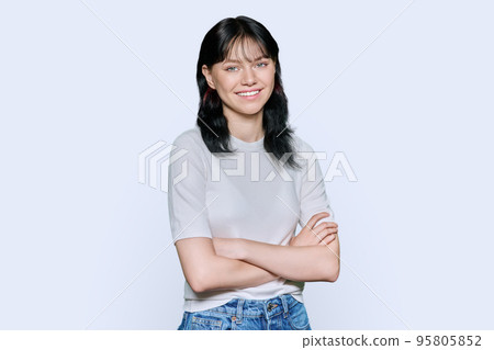 Portrait of positive young female with arms crossed over white background 95805852