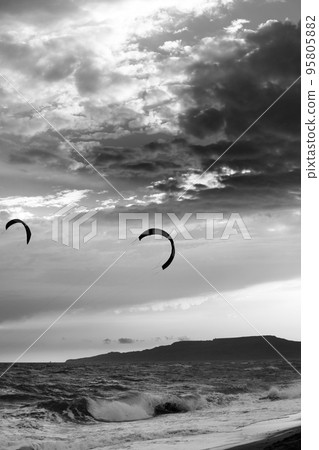 Two silhouette of power kites at sunset sky. Black and white. Two silhouette of power kites at sunset sky. Black and white. 95805882